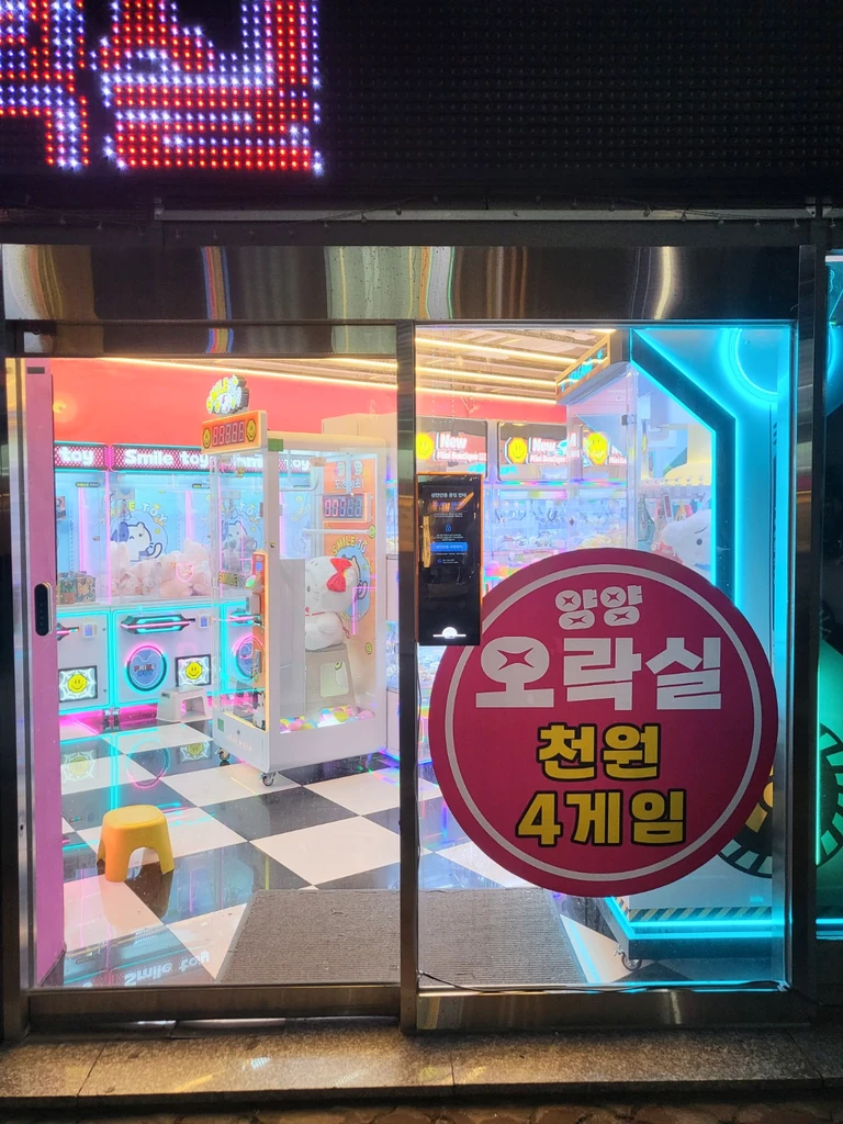 매장 외부에서 촬영한 유리 출입구와 성인인증기 설치 모습