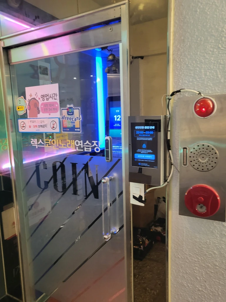 비스듬히 촬영한 출입문과 성인인증기 설치 전경