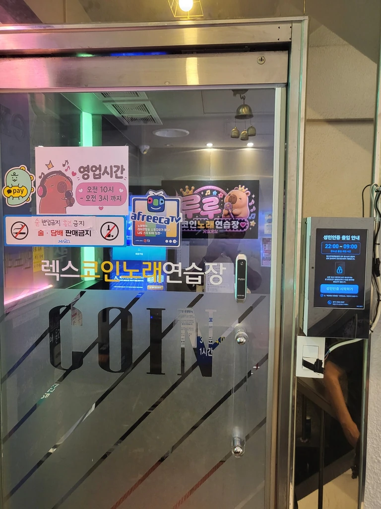 정면에서 촬영한 코인노래연습장 출입구와 성인인증기