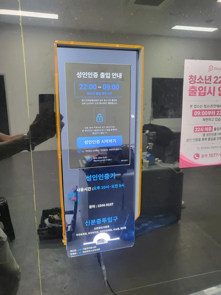 성인인증기 안내 화면과 하단 신분증 투입구 근접 모습